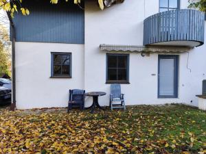 two chairs and a table in front of a house at FeWo Pfaffenhofen-Ortsteil Blick ins Grüne in Pfaffenhofen an der Ilm
