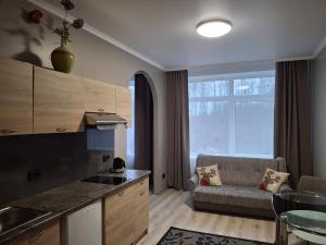 een keuken en een woonkamer met een bank bij VILLA ROZA Guest House in Rēzekne