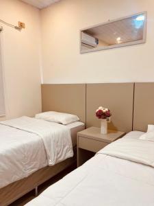 a room with two beds and a vase of flowers at SHINY House 2 habitaciones in Clorinda