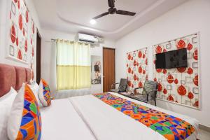 a bedroom with a bed and a tv on a wall at FabHotel AB Residency in Ludhiana
