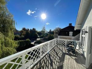 シャルロッテンルンドにあるLuxury home in Elite enclave - All floors heatedの空に太陽が輝くポーチの椅子