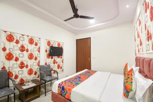 a bedroom with a bed and a tv on the wall at FabHotel AB Residency in Ludhiana +28 photos