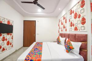a bedroom with a bed and a ceiling fan at FabHotel AB Residency in Ludhiana