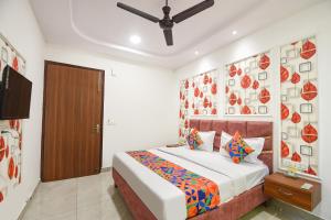 a bedroom with a bed and a ceiling fan at FabHotel AB Residency in Ludhiana