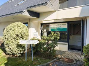 ein Straßenschild vor einem Gebäude in der Unterkunft Appartement cosy au cœur de La Forêt-Fouesnant, à 5 min de la plage - FR-1-481-121 in La Forêt-Fouesnant