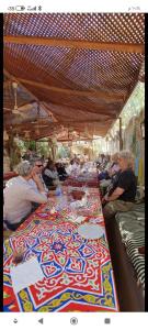 eine Gruppe von Menschen, die an einem langen Tisch sitzen in der Unterkunft Tibs mountain view in Al Aqālitah