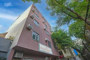 Un edificio alto y rojo con un cartel. en J Residency Near Nizamuddin Railway Station, en Nueva Delhi