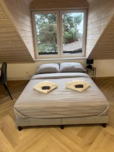 a bedroom with a bed with two towels on it at Przystanek Niesiołowice - na Kaszubach in Niesiołowice