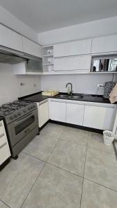a kitchen with a stove and a sink in it at Large apartment close to everything! North area in Cochabamba +26 photos