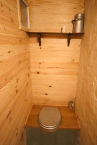 a small bathroom with a toilet in a wooden wall at Le Refuge de Bruno in Saint-Amans-Soult