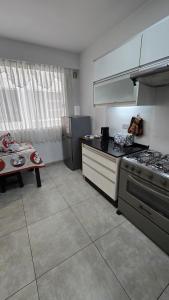 a kitchen with a stove and a table in it at Large apartment close to everything! North area in Cochabamba
