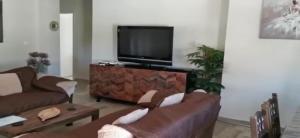 een woonkamer met banken en een flatscreen-tv bij Departamentos Márquez in Mar del Plata