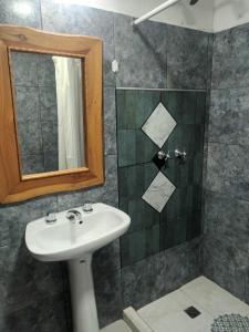 a bathroom with a sink and a shower with a mirror at Doña clotilde in Sierra de la Ventana +12 photos