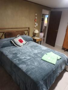 a bedroom with a blue bed with two towels on it at Doña clotilde in Sierra de la Ventana