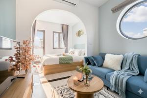 a living room with a bed and a blue couch at Label6 To Ngoc Van - Crescendo Boutique Studio in Hanoi