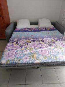 a bed with a floral blanket on top of it at Chez Rosalie in Lamentin