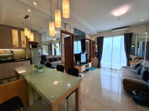 une cuisine et un salon avec une table et un canapé dans l'établissement THAMRIN RESIDENCE APARTMENT luxurious 1 BEDROOM FLAT SCBD beside GRAND INDONESIA mall, à Jakarta