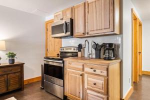 a kitchen with wooden cabinets and a stove top oven at Stunning Cabin Rental for Glamping Escapes Between Bryce Canyon and Zion National Park in Long Valley Junction
