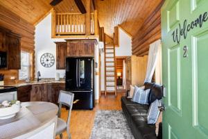 a living room with a black couch and a kitchen at Stunning Cabin Rental for Glamping Escapes Between Bryce Canyon and Zion National Park in Long Valley Junction