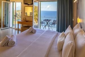 a bedroom with a large bed with a view of the ocean at Petani Bay Hotel - Adults Only in Vovikes +156 photos