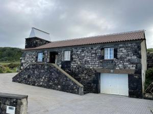 ein Steingebäude mit einer Garage und einer Treppe darauf in der Unterkunft Casa Rústica in Angra do Heroísmo