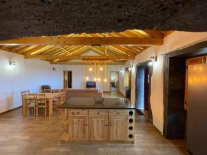 a kitchen and living room with a table and a dining room at Casa Rústica in Angra do Heroísmo