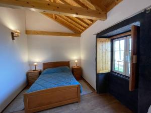 ein Schlafzimmer mit einem blauen Bett und einem Fenster in der Unterkunft Casa Rústica in Angra do Heroísmo