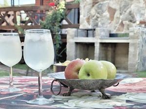 twee glazen water en een kom appels op tafel bij Cinnamon & Sage Country Cabins in Dullstroom