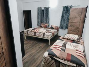 a room with two beds and a mirror at Shivay Adventure in Kevadia