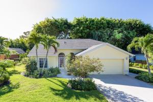 una casa con palmeras en un patio en SERENE & ATTRACTIVE 3BR HEATED POOL/SPA HOME, en Estero