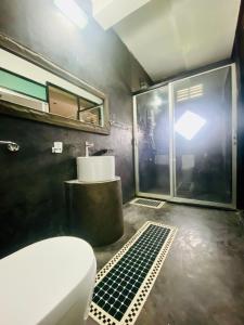 a bathroom with a toilet and a sink and a window at Cloudora Inn Kandy in Kandy +18 photos