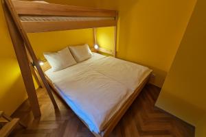 a small bedroom with a bunk bed with white sheets at Rodinný apartmán Pec pod Sněžkou 3 - 1x parking available in Pec pod Snezkou
