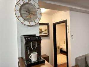 un reloj colgando en una pared sobre una cafetera en Casa Joy, en Bucarest