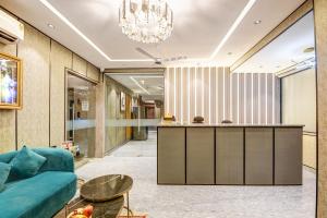 Un vestíbulo con un sofá azul y un bar. en J Residency Near Nizamuddin Railway Station, en Nueva Delhi