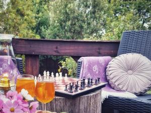 een schaakspel op een tafel met twee glazen bier bij Cinnamon & Sage Country Cabins in Dullstroom