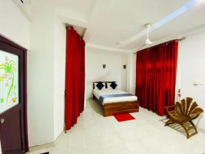 1 dormitorio con cortinas rojas, 1 cama y 1 silla en Cloudora Inn Kandy, en Kandy 25 fotos más