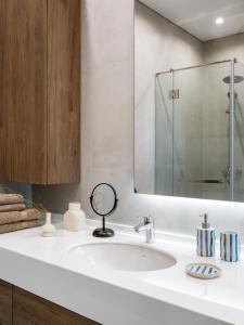 a bathroom with a white sink and a mirror at A27 Apartments in Almaty +31 photos