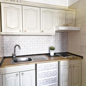 eine Küche mit weißen Schränken und einer Spüle in der Unterkunft Seguro El Sol en Playa de la Arena in Puerto de Santiago