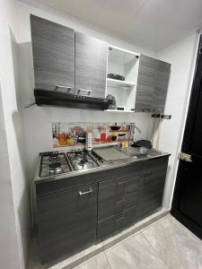 eine Küche mit einem Kochfeld in einem Zimmer in der Unterkunft Apartaestudio Vacacional en Girardot, piscinas, Jacuzis, parqueadero para moto in Girardot