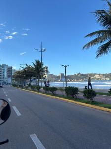 a person walking down a street next to the beach at Residencial Lara 9 in Itapema