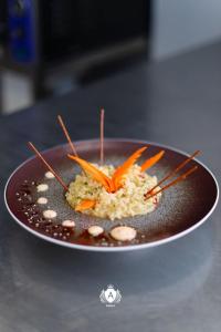 a plate of food with carrots on top of rice at Hotel Kraja in Golem