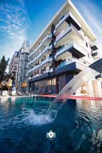 a water fountain in a pool in front of a building at Hotel Kraja in Golem
