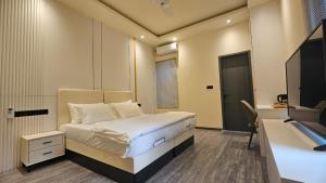 Un pequeño dormitorio con una cama y un televisor. en Oceara Dharavandhoo, en Dharavandhoo