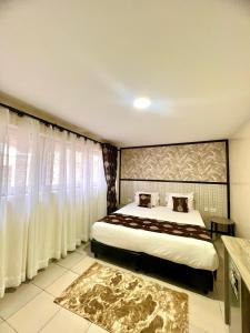 a bedroom with a large bed with white curtains at Hadassah Hotel in Nairobi +26 photos