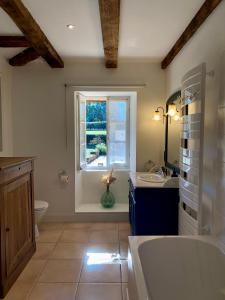 ein Badezimmer mit Badewanne und Waschbecken und einem Fenster in der Unterkunft Domaine de Cazal - Gîte 4 pers avec piscine au cœur de 26 hectares de nature préservée in Saint-Cyprien