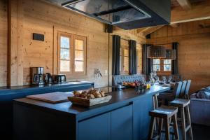 a kitchen with a blue island in a room with wooden walls at Chalet K - OVO Network in Chelou
