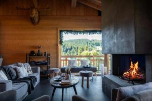 a living room with a fireplace in a log cabin at Chalet K - OVO Network in Chelou