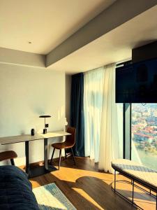 a living room with a desk and a large window at Apartment with sea View in Batumi