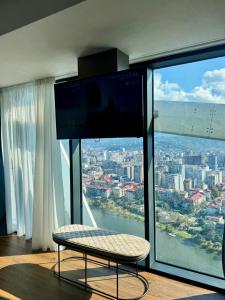 a room with a large window with a view of a city at Apartment with sea View in Itʼkhvisi