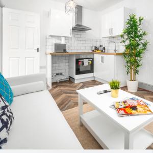a white living room with a white couch and a table at Modern Apartment - Wolverhampton Centre - Fast WiFi - Netflix 12AC in Wolverhampton +15 photos